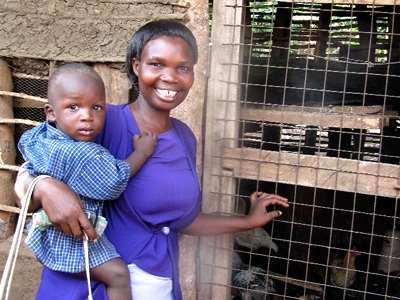 Woman with child besdie chicken coop